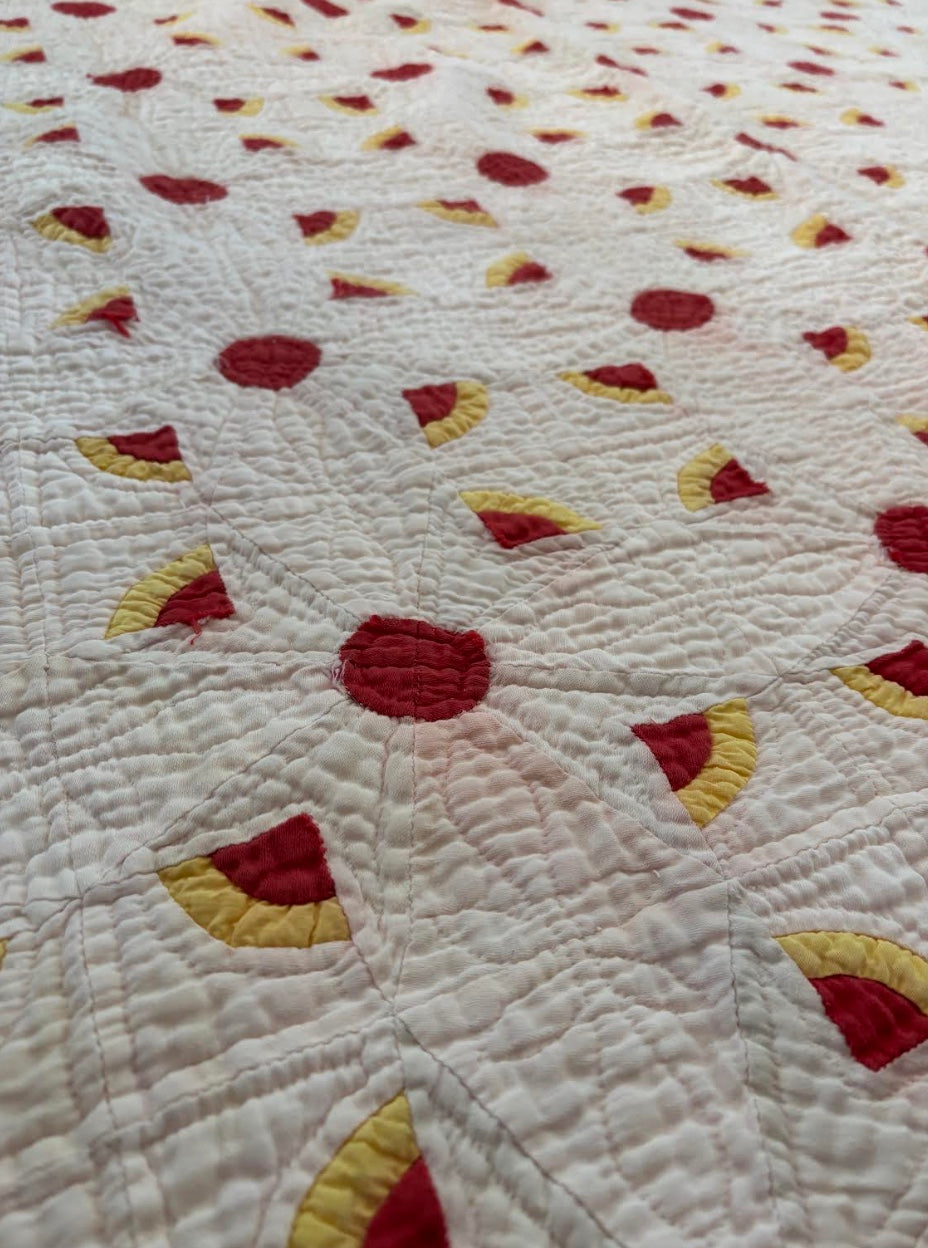 red, yellow, and pink handmade quilt